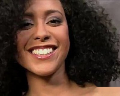 a smiling whore with blonde hair. A close up of her smiling in front of the camera.