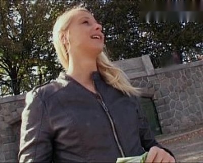 Pretty blond slut picking up money from tree and smiling at camera