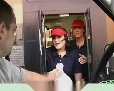 A cashier hands over money to a customer who is also wearing a headset.