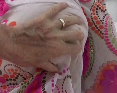 A whore is rubbing a ringed finger between her tits.