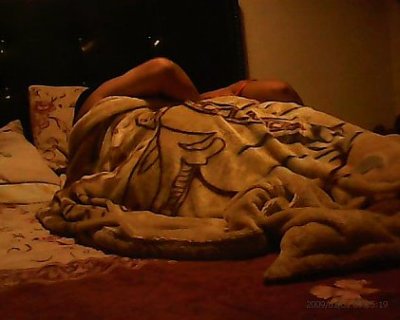 Person wrapped in a blanket on a bed.