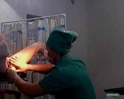 A person in green scrubs is attending to a baby.