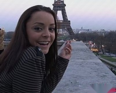 Cute French girl winking at Eiffel Tower