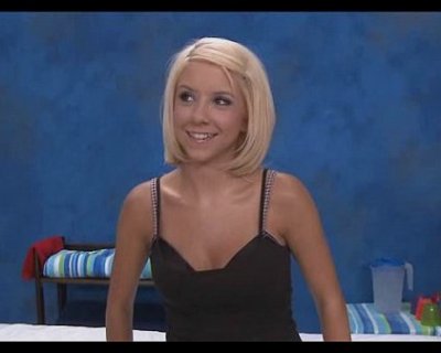 A blonde lady is smiling and wearing a black and white dress.