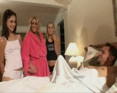 A male is lying in bed with a white sheet on him.