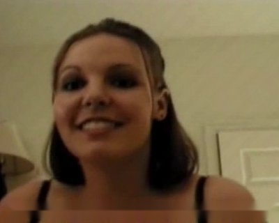 A young lady wearing pearl earrings is smiling for the camera.
