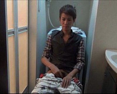 Asian boy sitting on a toilet with his pants down