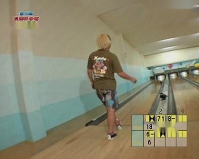 A male is walking on a bowling alley.