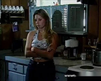 A whore with long hair looks at a sink.