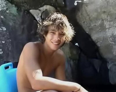 Shirtless fucker sitting in front of rocks