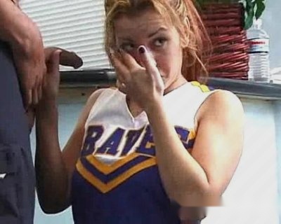 A girl with her eyes closed while an adult holds up something between them.