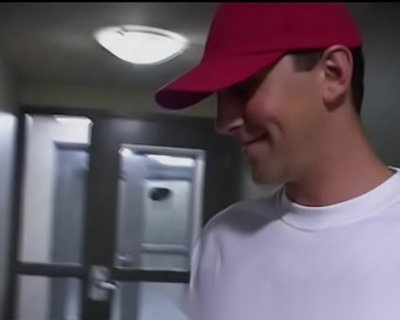 A male in a red cap is wearing a Big Sausage shirt.