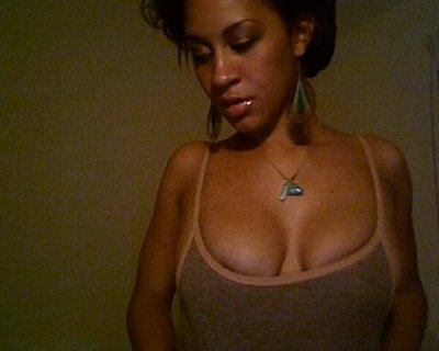 A girl is posing for a camera. Her earrings are green.