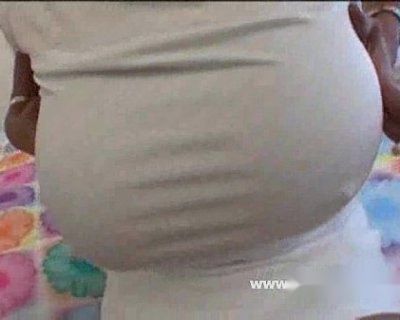 The whore is pregnant. The large belly shows that she is expecting a child.