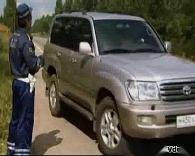 Police officer directing at driver. The officer is leaning on the vehicle and giving directions.