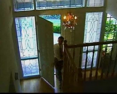 man walks up stairs. He stands at the top looking down.