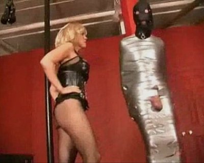 whore dancing in black corset. Pole has black tape.